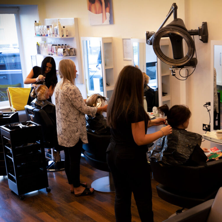The interior of Bliss Hairdressing salon, Heaton Chapel with three stylists working.